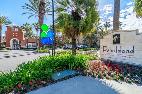 A sign for Palm Island in front of a building.